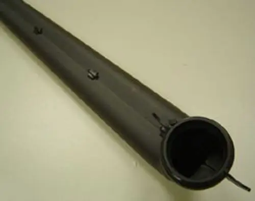 Schalldämpfer von Remeha, länglicher, schmaler Körper mit Öffnungen und einem runden Anschluss. Hintergrund in neutraler Farbe.